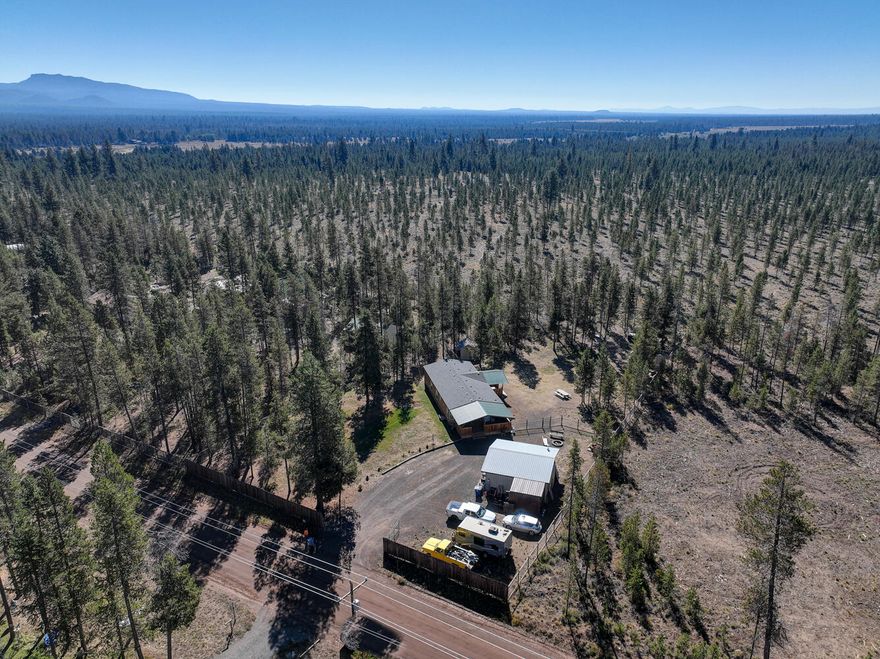 Home & Garage/Shop on 1 Acre Backing Public Lands! 3Bd/2Ba, 1994 built manufactured home on full Block Foundation & FHA/VA tie-downs!  Fully fenced & cross fenced for animals with a front security gate backing to large parcel of BLM land for additional privacy! Open floor plan with master suite & laundry/mud room, covered front & back decks, frame built storage building, chicken coop, large detached 576 sqft insulated garage/shop built in 2000 and a brand new roof in 2021! Close to La Pine State Park & Little Deschutes River!