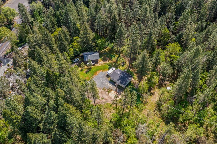 This beautiful park like property is home to a 2 bed/1 bath 972 SQ FT manufactured home built in 2018. The home is on a permanent block foundation and features an energy star package, open floor plan and a certified wood stove. This country setting of over 5 acres features a large seasonal creek, lush forest, and a grassy meadow. Also on the property is a 20' x 30' garage/barn and a 40' Container set up nicely for storage & a toolshed. The house sits up on a knoll looking over the green forest and meadow below. In the eastern side of the property you'll find a serene setting with Carter Creek flowing through the property as well as many native flowering Pacific Dogwood Trees. The driveway is on the property. Property was surveyed in recent years and it flagged/pinned at the corners. Part of the property is fenced. Well was around 50GPM when drilled in 1983, so flow would likely be limited to pump's max output. Septic system was installed in 1980 and was designed to serve 3 bedrooms.