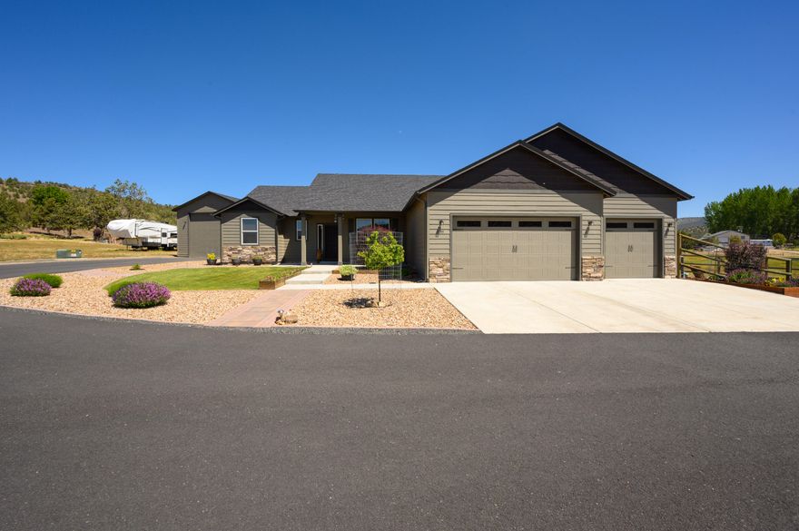 Highly upgraded and nearly new single level home w/triple garage and detached 24'x40' shop on 2.35acres on the edge of Prineville. The tastefully tiled and open foyer welcomes you into a bright great room that features a fireplace, kitchen w/quartz counters/breakfast bar, stainless appliances, a large dining area, and a pantry. On the northern side of the home the primary suite has a large bedroom w/space for a king bed and seating/TV area and the bathroom has a double vanity, tiled bath floors, soaker tub, shower w/glass door, enclosed toilet, linens closet, & an enormous walk-in w/window. Adjacent to the primary and the foyer there is a powder room. The south end of the home has two large guest bedrooms w/jack & jill bath. Office/4th bed location is central and next to a spacious utility w/sink that leads to the garage. The insulated shop has a 14' door, 2 cadet heaters, a pellet stove, & 200amps of power. The back yard is fenced/landscaped w/garden beds and a sprinkler system.