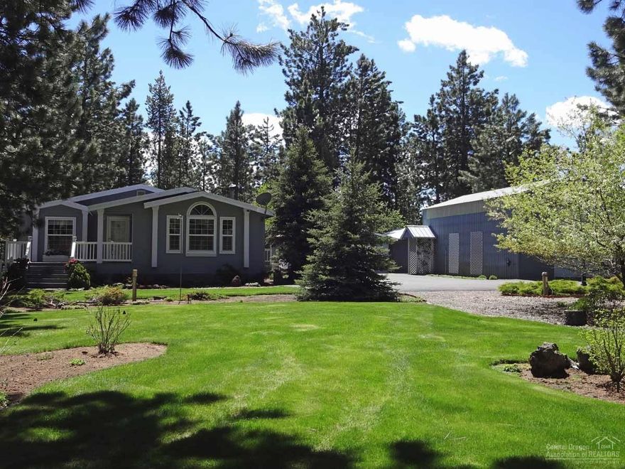 Spectacular move-in ready Goldenwest Country Estate triple-wide manufactured home. Open living, vaulted ceilings, hardwood and carpet flooring, certified wood stove, kitchen updated with stainless steel appliances and tile backsplash. Spacious master suite with big walk-in closet. 36x20 RV garage, 24x24 2-car garage, 16x20 wood shed, and 14x14 storage shed. Fully fenced with mature landscaping, sprinkler system, extensive wood decking, new septic tank and paved driveway. Home warranty included.