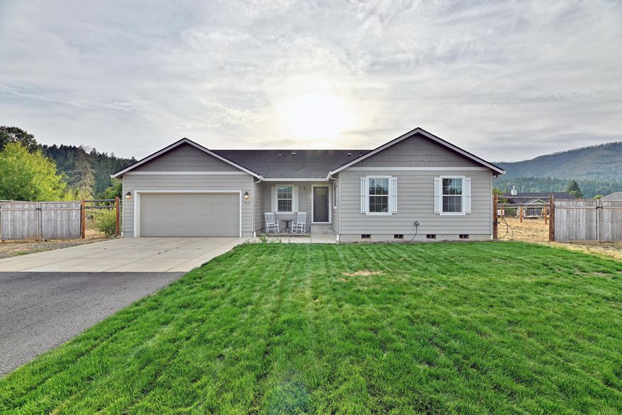 Welcome to your dream home in one of Cave Junction's most desirable gated communities! This 2021-built Hayden Home offers 4 spacious bedrooms, 2 full baths, and 1628 sq ft of thoughtfully designed living space on just under an acre of flat usable land. Step inside to vaulted ceilings, a split floorplan ideal for privacy, and a dedicated office space perfect for remote work or study. The open-concept kitchen features a large island & built-in microwave, modern finishes, and flows seamlessly into the main living area — perfect for entertaining. The primary suite includes a walk-in closet and a private bath for your own personal retreat. Enjoy outdoor living with timed sprinkler systems in both the front and backyard and take in the sweeping views of the Illinois Valley. Don't miss this rare opportunity to own a modern home with space, views, and access to some of Southern Oregon's finest natural beauty!