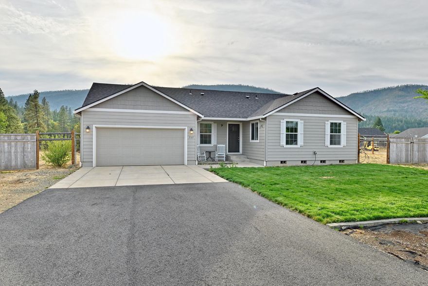 Recent 17k price reduction! Welcome to your dream home in one of Cave Junction's most desirable gated communities! This 2021-built Hayden Home offers 4 spacious bedrooms, 2 full baths, and 1628 sq ft of thoughtfully designed living space on just under an acre of flat usable land. Step inside to vaulted ceilings, a split floorplan ideal for privacy, and a dedicated office space perfect for remote work or study. The open-concept kitchen features a large island & built-in microwave, modern finishes, and flows seamlessly into the main living area — perfect for entertaining. The primary suite includes a walk-in closet and a private bath for your own personal retreat. Enjoy outdoor living with timed sprinkler systems in both the front and backyard and take in the sweeping views of the Illinois Valley. Don't miss this rare opportunity to own a modern home with space, views, and access to some of Southern Oregon's finest natural beauty!