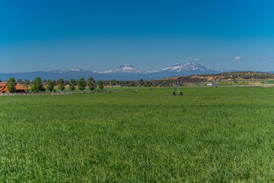Stunning 56-acre property offering premier agricultural functionality with breathtaking Cascade Mountain views. Currently in high-yield hay production, this exceptional parcel includes 56 acres of COID water rights and produces approximately 350 tons of premium hay annually. Infrastructure is fully in place for efficient, modern farming: two center pivots, multiple hand lines, and a recently lined irrigation pond with newer pumps—all automated via Ag Sense for seamless operation. A Conditional Use Permit is secured, allowing you to build your dream home amidst full, unobstructed views of seven Cascade peaks. The proposed homesite is thoughtfully plumbed for irrigation from the pond. Power is available at the lot, and a third-party well provides water access. Rarely does a property combine this level of productivity, natural beauty, and readiness for your future home. Don't miss this unique opportunity to live and farm in one of Central Oregon's most picturesque settings