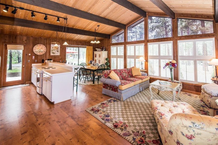 Elegant cottage style w/ cabin accents. Single-level home, close to the Village Mall & SHARC. Desirable open-concept floor plan w/ floor-to-ceiling windows & lots of natural light. Vaulted ceilings w/ beautiful wood-accents & exposed beams. Charming glass-faced kitchen cabinets, large-breakfast bar. Laminate wood-like floors. Wood-burning fireplace, built-ins, central A/C. Updated master bedroom & bath. Separate utility room w/sink. Enjoy your morning coffee or afternoon BBQ on large paver-patio. A charmer!