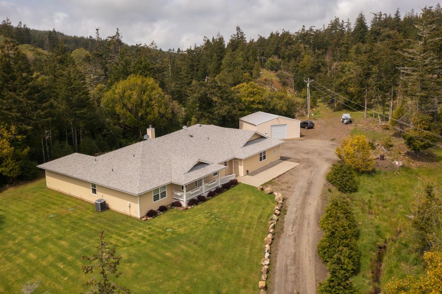 Enjoy quiet solitude and beautiful views of trees and foliage from every window! This custom home on 20+ acres sits on a hill, just minutes from Gold Beach and the Rogue River, and includes its own running creek. The 4 bedrooms include two primary suites, one being fully ADA compliant and accessed by an extra wide hall and doorways. The other primary suite features two walk-in closets. Open floor plan, with soundproofed office off the main entrance and hardwood floors. You'll stay cozy with the wood stove and heat system with 3 zones, and never wait for hot water thanks to the circulating pump. Listen to birds as you relax on the covered back porch. Attached, 3-car, extra deep garage. 30'x32' shop with 10'x12' doors, and 3-cord woodshed. World class fly fishing and Oregon coast beach activities abound in the area, making this property perfect for a primary residence or vacation home.
