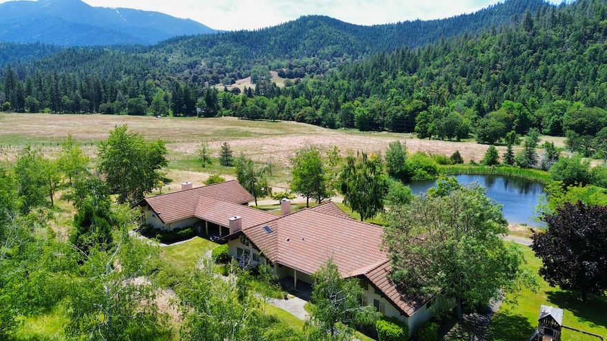 Welcome to Eagle's Nest Ranch. 114 acres of usable land, scenic views & lush forest in the world-renowned Applegate Valley. The 4000+ s/f ranch-style home overlooking an alluring pond & stunning mountain views offers single story living with multiple family rooms, fireplaces, large country kitchen & studio attached by a breezeway. Enjoy Thompson Creek flowing through the property, multiple ponds & district irrigation. The original cabin with separate address & gated entrance provides potential space for extended family, caretaker, or rental income! Multiple outbuildings include barns with tractor & hay storage, livestock feeding areas, equipment sheds & workshops. This private paradise consists of usable cross-fenced acreage and is bordered on 2 sides by over 10,000 acres of BLM land offering endless recreational & wildlife viewing opportunities. Eagle's Nest Ranch offers the best of rural Oregon, located in the Applegate AVA near vineyards, wine tasting rooms & historic Jacksonville!