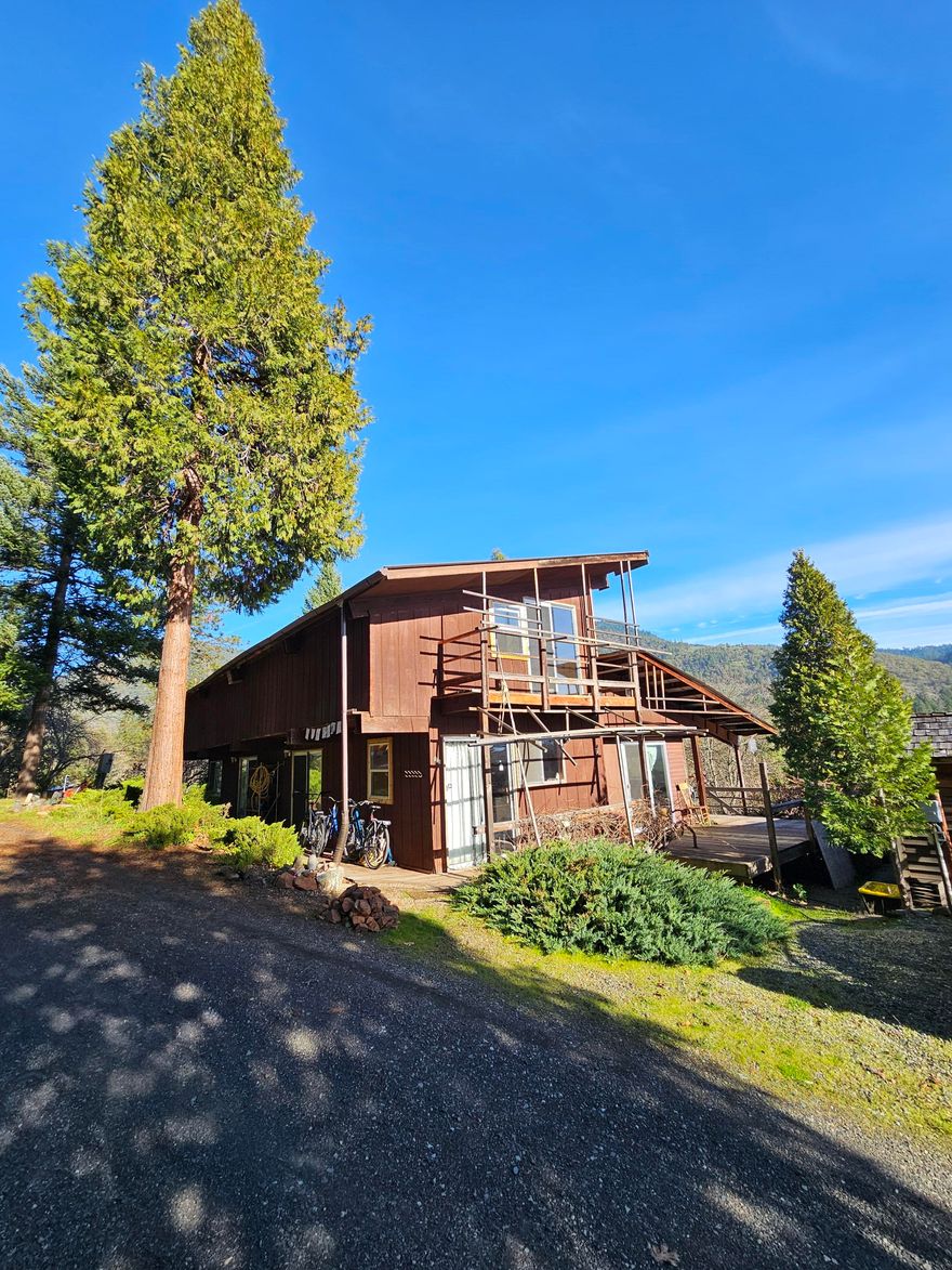 Here is your chance to secure beautiful acreage in the Grants Pass country side. The home is tucked at the end of the drive way for lots of privacy. Multiple improvements have been made to the property including several well-built cabins for guests. A new 9x6 cedar wood fire sauna. 60 gallon per minute well with dual water softeners! The home was remodeled nicely! Beautiful views of the mountains and valleys from your front porch. Drivable trails that take you all over the large acreage property with many different paths to walk. Several green houses perfect for off the grid living. Come see it today before its gone!