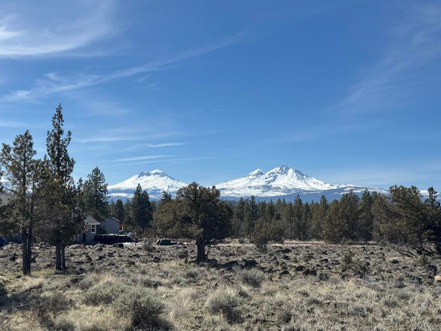 Nestled on just under 5 pristine acres, this exceptional property in Sisters, Oregon, offers breathtaking, unobstructed views of the Cascade Mountains and the quintessential High Desert landscape of sagebrush, lava rock, Ponderosa and Juniper. Located at the end of a road, in a quiet neighborhood with large multi-acre lots, the property provides the perfect balance of seclusion and convenience and is just minutes from charming shops, golf, restaurants, and all the amenities of downtown Sisters, in addition to being just a stone's throw from hiking trails, lakes, creeks, camping, Hoodoo Ski Resort. Whether you're looking to build your dream home or simply enjoy the serene high desert landscape, this is a rare opportunity to own a truly one of a kind slice of Central Oregon paradise. There is a fully functional mobile home and two outbuildings that can be rented or lived in as you build your dream home.