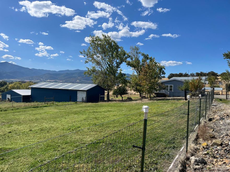 Wonderfully updated/remodeled 4 bedroom 1993 manufactured home sitting on 5.23 acres.  Living, kitchen and bedroom areas have been completely remodeled from the floors up.  New Kitchen, laminate flooring throughout, paint, kitchen cabinets and counters, fixtures, dishwasher and refrigerator.  This property has 4 acres of TID Irrigation.  Many outbuildings including a barn with several stalls, hay storage, 2 detached carports, shop and 4 bay equipment covered storage. Perfect 4-H set up for all your projects.  Plenty of fenced space for animals and a garden area.  This rural property is ideal and within approximately 10 minutes to either Medford or Ashland. Enjoy the sunsets while overlooking your property and relaxing on your deck.
