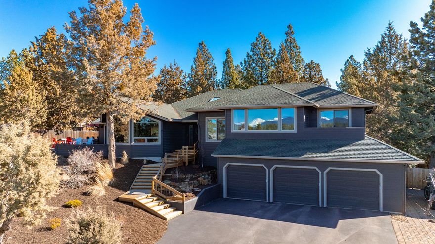 Perched on a bluff at the foot of Awbrey Butte, this newly remodeled home blends modern sophistication with thoughtful design. Stunning Cascade views enhance the open, airy layout, where no detail is overlooked—from the living room's walnut mantle to the vaulted dining space and fully redesigned butler's pantry.  
At its heart, the gourmet kitchen features honed Carrera countertops, Thermador appliances, a custom walnut island, and a newly added beverage bar for effortless entertaining. The spacious primary suite boasts a reconfigured layout, while the luxurious bath offers custom walnut cabinetry, heated floors, and a freestanding tub.  
Outside, enjoy a redesigned yard with a pickle ball/basketball court, fenced backyard, sauna, treehouse, zipline, and a heated custom-built she-shed. Mature pines and lush landscaping complete this serene oasis.