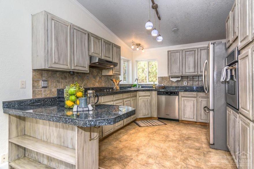 This lovely home is nestled on 1.75 acres and is brimming with potential.  Well thinned, mature Ponderosa pine trees provide shade around this thoughtfully maintained home on corner lot. Home features 3 bedrooms, 2 baths and a family room with wood burning fireplace. Kitchen has been updated with granite tile and stainless steel appliances. Laminate flooring in the large great room. Spacious laundry room with sink and built in desk area. Outside, you'll find an over-sized three car garage with extra storage, hobby  space and workbench. Plenty of space for parking your RV, complete with power and septic hook up.   Could also work for muti-generational living. Live close to all that Bend has to offer while enjoying a private, park like setting with plenty of room for all your interests and hobbys. See the virtual tour link for more photos and views of this property!