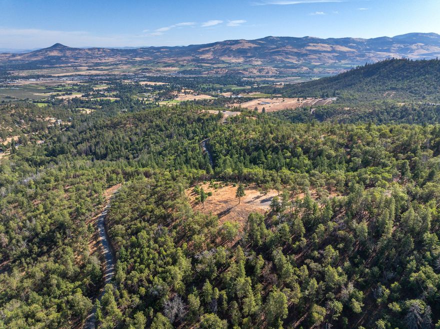 Parcel 6 includes onsite utilities, a 46 GPM private well, and septic approval.  It enjoys a territorial view that encompasses the high mountain ridge across the Coleman Creek valley below & looks further out to the vineyards & farms dotting the landscape. The homesite is placed at the highest elevation with the access coming from above, allowing for possibilities of a daylight basement or large cantilevered deck overlooking room for a beautiful landscape below in the gently sloped yard. The main road provides access to the lower portion of the property providing ample space for an RV barn or shop location. Coleman Hills is a premier gated community that has been meticulously designed as a private & luxurious rural living experience with long range valley views. Southern Oregon is a recreational paradise, with access to massive public lands, phenomenal hiking, & great camping! Come enjoy the views from Coleman Hills! OWNER CARRY TERMS AVAILABLE.