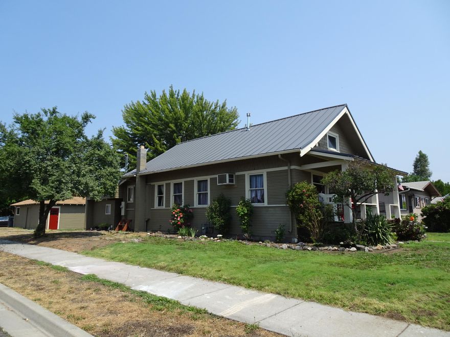 Charming and open floor plan in this darling 4 bedroom 2 bath Craftsman home with hardwood and tile floors through the entire main portion of the house. Original built-ins and nice woodwork touches, maintaining its original integrity. Attractive and functional gas heat fireplace; solid surface soap stone kitchen counter tops, Bosch dishwasher, gas stove and deep farmhouse style sink overlook flagstone patio and prolific plum tree. Roomy dining room too! You will love all the extra storage including the oversize garage workshop in the back yard. Lot is good sized at .18 acres and perfect for a gardener. New metal roof added one month ago over main portion of the house and 5 years ago on the back addition. If you love a home with character and long covered porches, this is the one for you! Close to city parks, Jewett elementary & shopping. Extra parking for toys and RV off alley behind Workshop/garage.