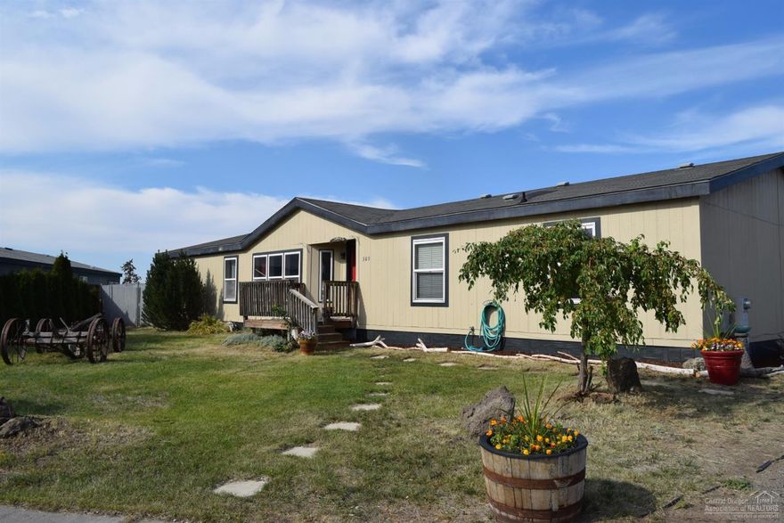 Great floor plan with 4 bedrooms, 3 baths, 1782 sq ft mfg home with large kitchen featuring, tiled granite counter tops, gorgeous cabinets, eating bar, mostly bamboo flooring, light and bright with skylights, built in extras, split bedrooms, pellet stove, and nice deck for entertaining, detached garage, extra storage building, large backyard needs your inspiration, tall chain link fencing, raspberries and nice trees. Paved road with sidewalks in a central location. Ideal. Please call for private showing.