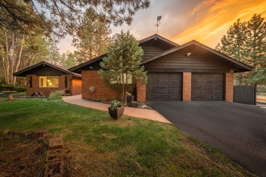 Experience refined living in this modern ranch retreat on 2.59 private acres in Bend's Woodside Ranch. A comprehensive remodel preserved the rare brick exterior while completely transforming the interior into a sophisticated single-level sanctuary. Vaulted 16' ceilings with exposed beams, floor-to-ceiling windows, and engineered hickory floors frame an open, light-filled design. A European-inspired kitchen, spa-like baths, sunroom, and office blend modern luxury with timeless comfort. Outdoors, a hot tub, pergola, expansive deck, naturalized pond, mature aspens, and a dramatic lava tube create a truly unique setting. The 2,247 SF residence includes 3 bedrooms, 2 baths, and a 2-car garage, complemented by a 780 SF greenhouse with plumbing, power, and storage that offers future potential for expanded use. With all new systems and meticulous craftsmanship throughout, this turn-key estate offers privacy, elegance, and effortless connection to Bend's trails, lakes, and mountain lifestyle.
