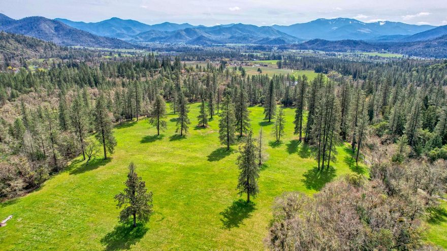 Nestled in the heart of the Applegate Valley, this exceptional 170-acre property boasts a rich history dating back to 1894. Featuring over 82 acres of water rights, the land is graced with 1+ mile of Miller Creek frontage, supplemented by high-producing wells (100gpm), a spring-fed pond and additional domestic wells. Power is supplied with 2 meters. Outbuildings include a 7,200 sf barn with stalls, storage & shop areas with cement floors, arenas, corrals, scales, and chutes. Recent home site approval for a dream home, complete with septic, power and RV hookups, adds to the appeal and ease. Currently seeded with cover crops for hay and pasture, the remaining acreage is wooded, offering abundant hiking, horseback riding and mountain biking trails. Adjacent to BLM and state forests, this land is ideal for an organic vineyard, hunting lodge, family retreat, or conservation resort. The possibilities are endless on this stunning, secluded box canyon with abundant water resources.