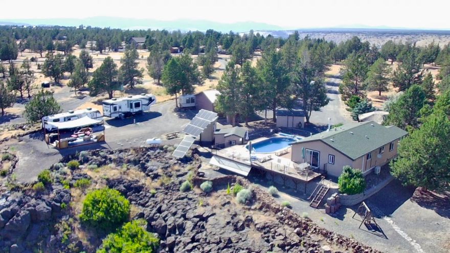 RARE OPPORTUNITY-Seller will consider Owner Carry Contract! 2B/R 2B/A on 6.2 acre rim property w/expansive Mt. views including 3 Sisters from custom decking. Totally remodeled inside & out w/custom solid wood kitchen cabinets, ss appliances & over-sized dual-level island  for entertaining, open concept LR & DR areas w/propane fireplace. Primary B/R & Bath have been up-graded PLUS w/mini-split AC in Kitchen & Primary. Slider from  BR2 steps onto expansive decking + man door from laundry rm leading to continued decking & huge above ground pool. Front door leads out to full covered  porch & lg. 850 sf paver area w/custom gazebo covering handmade octagon propane fire table for entertaining. Numerous additional entertainment sights throughout the property. 30X30 shop for toy storage & ample parking for family & friends' RV's Custom entertainment area w/kitchen & seating designed to pull your trailer up to for outside comfort. Focal Point: Pool, 3 piece ''Bath House'' MUCH more. Must see.