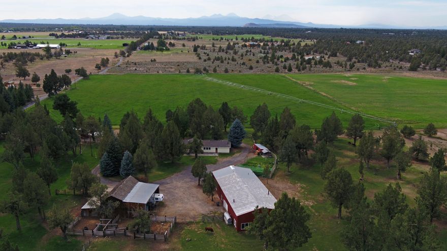 Cascade Mountain Views from private 40 acres that has two legal lots of record: 8.49 acres with home and buildings and 31.5 acres with a building site ready for a single family residence with power and septic feasibility completed. Property has 27 acres of COID water rights currently producing hay for horses/livestock. 5 pastures has a large year-round pond, perfect for great family memories swimming, bass fishing from the dock, or boating! Well maintained, updated 2,040 sq ft ranch style home is 4 bedrooms, 2 baths, large open kitchen, breakfast bar, dining area, living room with vaulted ceilings and wood burning fireplace. The oversized attached 2-car garage boasts a heated man cave and walk-in pantry. Newer steel Shop is 40x99 (3960 sq ft), 200 amps, heated, bathroom, kitchenette, office, RV storage, dump and hookups. The property is fenced, gated, borders COID land leading to BLM and is in Bend school district. This is a rare opportunity approximately 10 minutes from east Bend