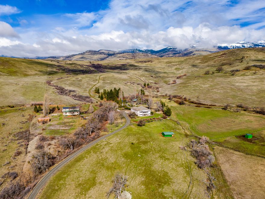 Very private ranch estate with rare potential two-family setup built by Asher Homes on serene acreage in the foothills of Grizzly Peak - just 10 minutes from town! Main home with panoramic valley views, high ceilings, living room, great room, formal and informal dining, spacious kitchen, half-bath, laundry room, covered deck, two-car garage, main-level primary with full ensuite bath, lower family room, covered patio, two bedrooms, and full ensuite guest bath. Fully permitted detached barn converted to finished living area with kitchen, half-bath, laundry room, living and recreation room, bedroom, office, full bath, separate septic and water filtration, 9 kW solar array, and 720 SqFt shop. Greenhouse, pole barn, and detached two-car garage with additional 13.5 kW solar array. Irrigated, fenced, and cross-fenced usable acreage with southern exposure. Contiguous parcels make up over 975 acres of undeveloped rural land - more than half owned by the City of Ashland. Inquire for details!