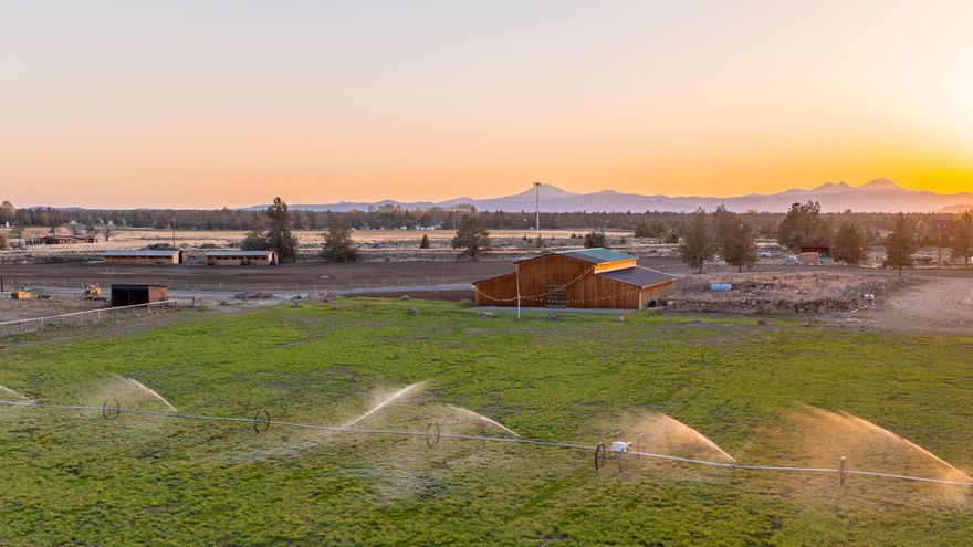 Discover a rare & timeless opportunity to own over 160 acres of pristine Central Oregon countryside just beyond the Bend city limits. Surrounded by sweeping mtn vistas & endless blue skies, this exceptional estate blends natural beauty w/ modern functionality—perfect for a discerning buyer seeking a private sanctuary or a visionary entrepreneur ready to cultivate a thriving agribusiness. 85+ acres of deeded COID water rights, this property is fully equipped for 21st-century farming, featuring a state-of-the-art app-controlled pivot system & multiple wheel lines for efficient irrigation. The custom-built farmhouse features dramatic vaulted ceilings, a gourmet chef's kitchen, 2 primary bdrms & a covered deck offering unobstructed views of the Cascade Range. A newly constructed, multi-purpose ~10,000 sq. ft. barn—complete w/ baths—offers endless potential. New outdoor riding arena & 4 stall barn. A large concrete platform poured on the east side to host events. Land owner preference tag.