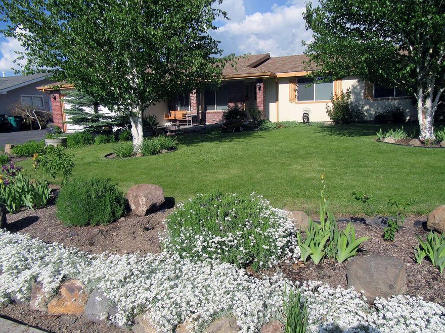 Well maintained undated home in desirable Sunset Village. Featuring 3 bed rooms, 2 baths, LR with fireplace, FR off tiled kitchen with eating bar and all appliances, vinyl windows, new carpet and laminate flooring, 16x21 Play/TV room, gas heat + A/C. Lovely mature landscaping, sprinklers, 12x16 hobby shop with power, back deck with seating for entertaining plus numerous storage sheds, pavered patio in front. RV parking, 2 car garage.