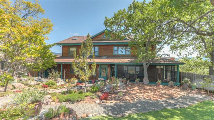 Views, Views, Views! This knoll top property has 360 degree views including Mt. Ashland and Emigrant Lake. This well maintained and spacious home has the most inviting gardens you have ever seen. Numerous flowering trees and shrubs accent the ground plus a separate areas for your vegetables. The unique floor plan situates the primary living areas and kitchen on the upper floor for maximum views. Extensive wood detailing accent the vaulted great room with fireplace. The master suite is nicely appointed and has great natural light. On the ground floor is a oversized bedroom adjacent to a screened in porch. It also has a secondary sitting room/den that is adjacent and even has a fireplace. Attached garage, detached bunk house, great privacy and so much more. Don't miss this Ashland gem!