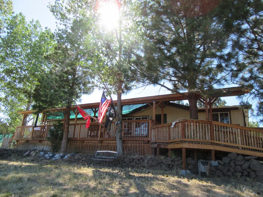 Enjoy country living in this very nice 1996 MH with 1,500 sq.ft. featuring handicap accessible ramp leading to a big covered front deck. Open floor plan with vaulted ceilings, dining area, a total of 3 bedrooms, 3 full baths, with 2 ensuite bedrooms that are ADA wheelchair accessible.  Kitchen with all appliances, including washer/dryer, pantry, breakfast nook. Mudroom off the dining area, Electric heat plus a swamp cooler. All on 3.69 acres, detached garage, a 3 stall horse barn with hay storage and a separate hay barn, + 3 small sheds, chicken coop. Right off a paved road, with nice basin views.