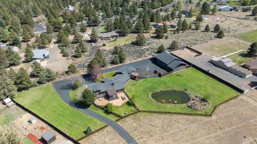 This exceptional 2.38-acre Bend estate seamlessly blends luxury, comfort and natural beauty. The fully remodeled 3,292 sq ft main residence showcases high-end finishes, including Acacia wood floors, travertine, porcelain tile, alder cabinetry, granite countertops, buffalo stone accents and vaulted ceilings. The expansive primary suite features a gas fireplace, soaker tub, walk-in shower, private deck, and direct hot tub access. A junior suite offers its own walk-in shower and private patio entrance, while a spacious upstairs bonus room adds versatility. The 624 sq ft detached ADU is perfect for guests, extended family, or rental income. Outdoor living is equally impressive with a covered deck, paver patio, built-in fire pit, pond with tranquil water feature and mountain views. The property is fully fenced and cross-fenced, with 2.0 acres of Avion irrigation, a 2400 sq.ft shop equipped with 12' doors and 220 power and water. All of this, just minutes from the heart of Bend.