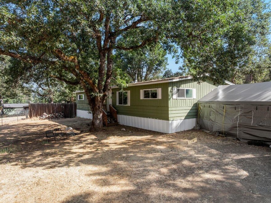 Come see this ready to live in 1975 built 3bd/2ba 1440 sqft manufactured home on 1.03 acres of EFU-zoned land! Recent upgrades include new well and power systems, offering modern reliability in a peaceful country setting. Home features a spacious 33x14 living room with beamed ceiling, large kitchen with ample storage, and a primary suite with dual closets and built-ins. Two full RV hookups with power, water, and sewer make this property ideal for guests, multi-generational living, or extra income. Detached garage, fenced backyard with fruit trees and roses. Enjoy flexible rural living with room to grow!