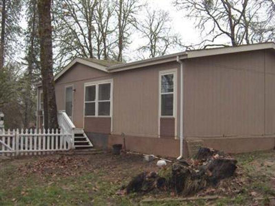 Peaceful, country living. Perfect for the first-time home buyer. 3bd/2ba on over a third of an acre just outside of town. Enjoy low maintenance with a country feel. Fully fenced, with large backyard, large (18'x52'' round) heated above ground pool with all equipment included, private, seasonal creek and partially wooded. This cozy manufactured home on land features double paned windows, newer heating/air, granite countertops, tons of cabinets, newer walk-in showers, vaulted ceilings, and ceiling fans. Outside you'll enjoy a covered front deck, covered back patio, large carport an d and excellent well. (15 gpm per seller.  Just 12 miles to Grants Pass and 5 miles to downtown Merlin. Don't miss this country living opportunity.