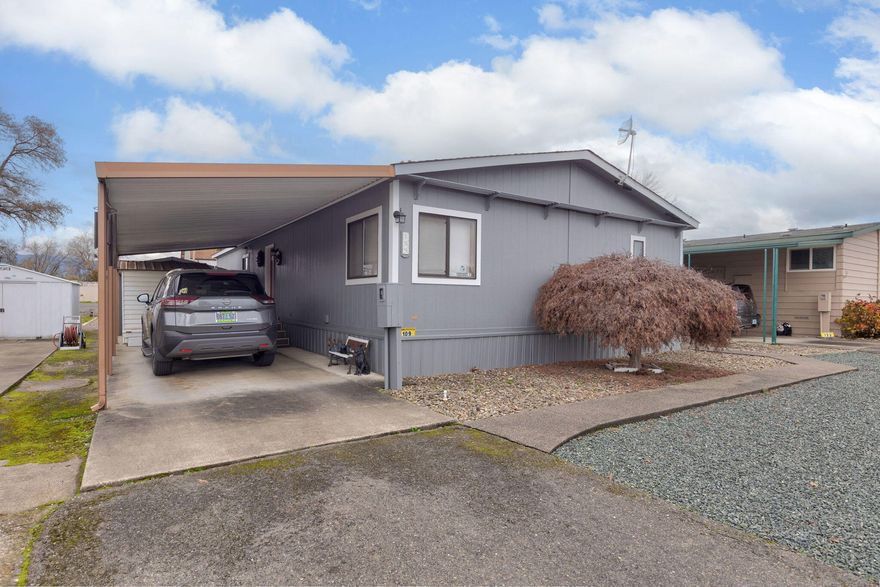 Pride of ownership shines here! Welcome to this well cared for home in RogueLea Estates a 55+ community.  Home has an open floor plan with a huge great room, separate dining area, a wonderful kitchen with lots of counter space, island and a breakfast bar.  There is a covered front porch for peaceful mornings enjoying your coffee.  Low maintenance yard for easy care and 2 sheds for plenty of storage. Second shed has power and a workbench. Home was painted and HVAC replaced in recent years.