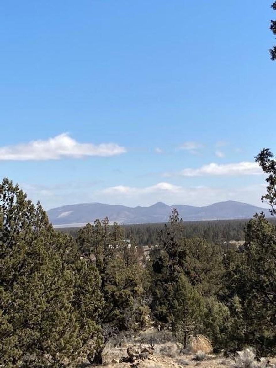 Smith Rock and Powell Butte views to the East from this spacious gently sloping 4 acre parcel in Whispering Pines. Desirable location between Bend and Redmond. Old growth Junipers and rock outcroppings will add to your landscape's character. Quiet paved street and quality homes in the area. Septic approved for a sand filter system. Water and power in the street at the property line. Corners are marked.