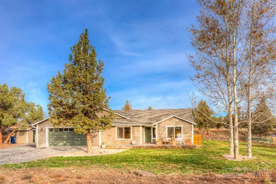 Custom single level home on 5.11 acres. 3 Bed/2 Bath with vaulted ceilings, Big Country Kitchen, with tile counters, Island & large pantry, knotty hickory cabinets, breakfast nook, breakfast bar AND Formal Dining! Den/Game Room w/ French doors, laminate & tile thru out. Large master w/ vaulted ceilings, 2 closets, nice tiled master bath w/ soaker tub, walk in shower & dble sinks. Delicious well water w/ good volume. Property is fenced & gated w/ 23x23 dbl attached garage & detached storage building.