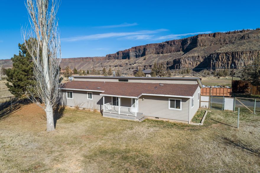 Tired of cookie-cutter homes?  Here is your chance to own a 1840 sq.ft. home with real character on 2.5-acres, in the heart of Crooked River Ranch. Master bedroom is separated from two guest bedrooms, plus large flex room would make a perfect mud-room or home office. Ceilings are vaulted with exposed rustic beams in the living room. A large stone hearth supports a cozy propane fireplace. Dry bar off the kitchen is perfect for entertaining or use as a breakfast bar. Stay protected from the elements in the enclosed sun porch, to watch the wildlife roam or bask in the Central Oregon sunshine from your fenced front yard. The beautiful 1960's two-stall barn with work shop room and enclosed hay/tractor storage still remains from the beginnings of the long history of this property and there is plenty of room to build the shop of your dreams! Property backs to public land from which you can see the Crooked River.  You won't find another home like this!