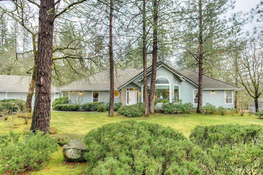 IMMACULATE home nestled in a lovely, sought-after neighborhood surrounded by huge trees and tons of wildlife, yet just minutes to town! 2560sf home situated on 5 wonderful acres. Enjoy the gorgeous rose garden, flowering trees, lush lawns, shade trees, mountain views and seasonal creek from the backyard deck, or out every window from inside the home! The home features an open/split single-level floor plan with 3 spacious bedrooms, 2.5 baths, plus an office. The great room is vaulted and open to the dining room and kitchen, with a brick wood burning fireplace. The kitchen features vaulted ceilings, hardwood floors, island w/ gas cooktop, ample cabinetry, double ovens and a large pantry. Enjoy your morning coffee in the light & bright sunroom! Lots of built in storage areas within the home, large laundry/utility room, oversized 3 car garage plus covered RV parking complete with hook-ups and dog kennels. Back yard area is completely fenced. Truly a must see!