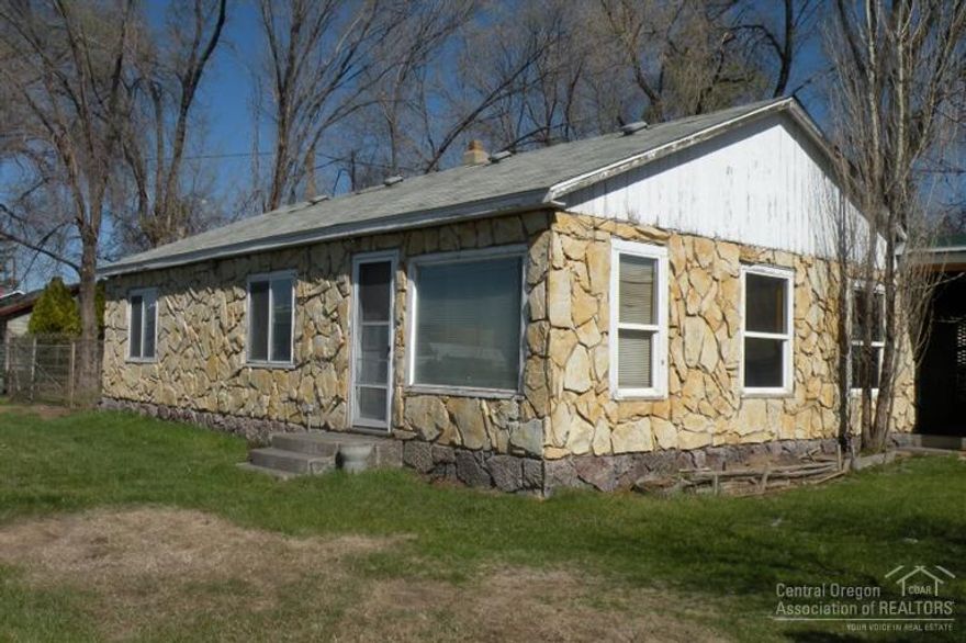 Home, shop, and storage building on large corner lot. Zoned for a variety of commercial and residential uses. Property need repairs and cleanup. Great potential for investment or development. Sold as-is.