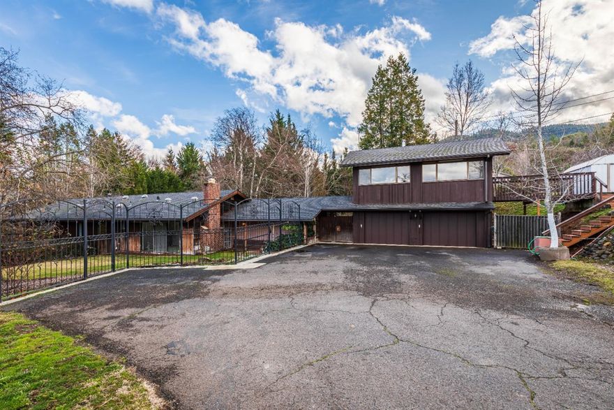 This property last changed hands when The Mickey Mouse Club premiered on TV, 66 years ago! Of course, additions and improvements have been made over the years. It is rare to find a large 2+ acre property in Ashland. The home is idyllically set overlooking Paradise Creek from the large master bedroom suite and balcony. Features include: new carpet, interior paint, art studio/shop above the 576 sq. ft. finished double car garage, fenced pasture, 2 stall barn plus a 17' X 25' shop area, deer fenced fruit orchard and garden area, irrigation rights to 1.8 acres in a park like setting yet close to shopping. This is an estate quality setting, but it is also zoned R-1-7.5 that may have development opportunities.