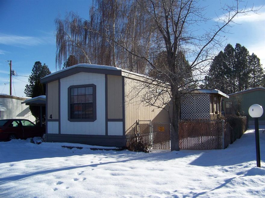 Nice mobile in Terrace Mobile Plaza. This home is configured for easy living and is handicap accessible. Covered front porch continues out to the storage building. Fenced front and back. Heat pump, electric forced air furnace, with an additional propane heating stove. Bedrooms are located at each end of the house with a bath next to each. Space rent is currently $391 per month which includes, water, sewer and garbage. Attached room out the back door for storage.