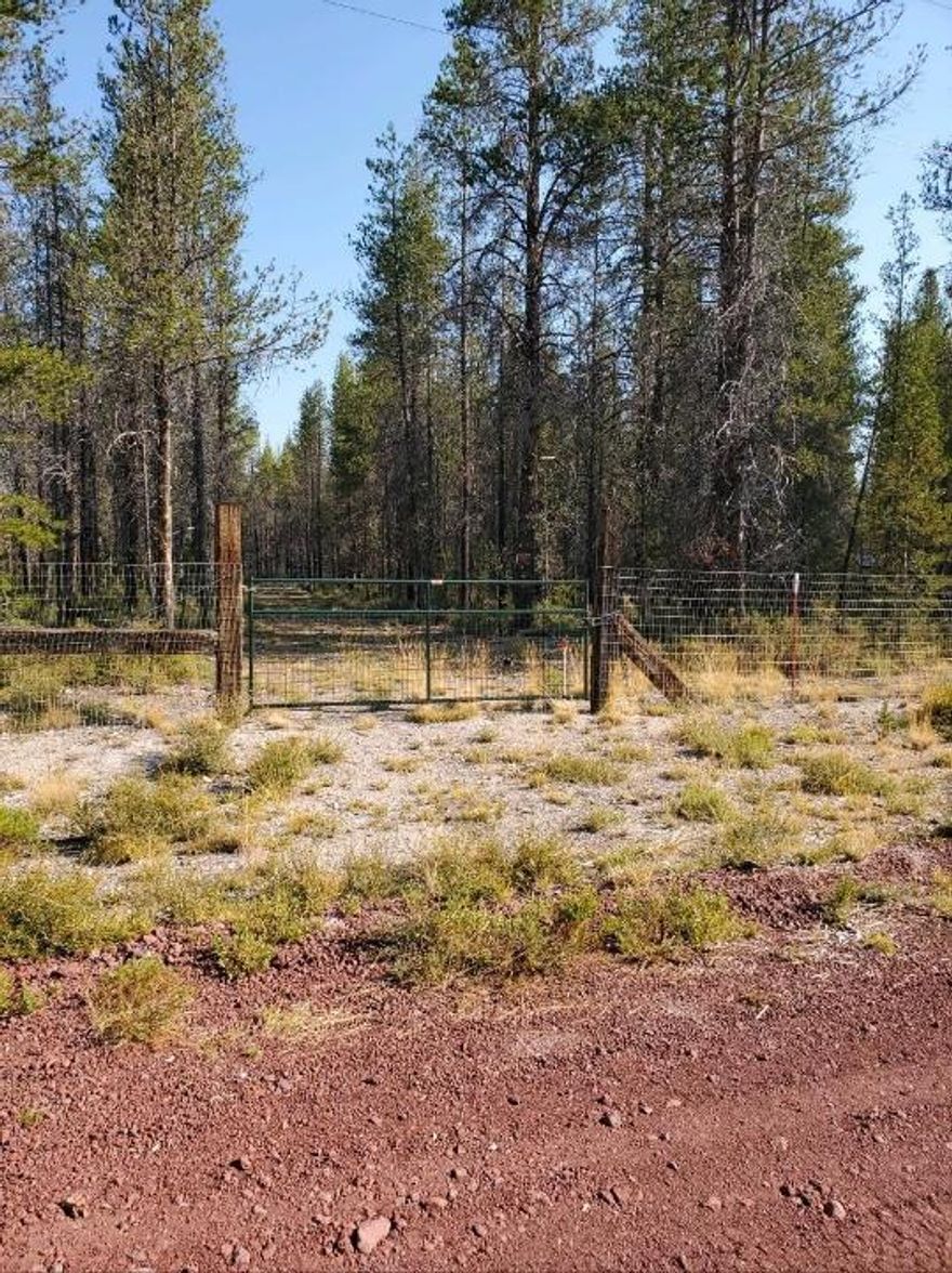 This level parcel in Mt Scott Meadows is covered with pine trees, has an excellent well with pump and perimeter fencing with two gates.  Corner lot is located in area of well-kept parcels.  The cinder roads are in good condition and power is available at the road.  Please call with any questions and a tour of the land.