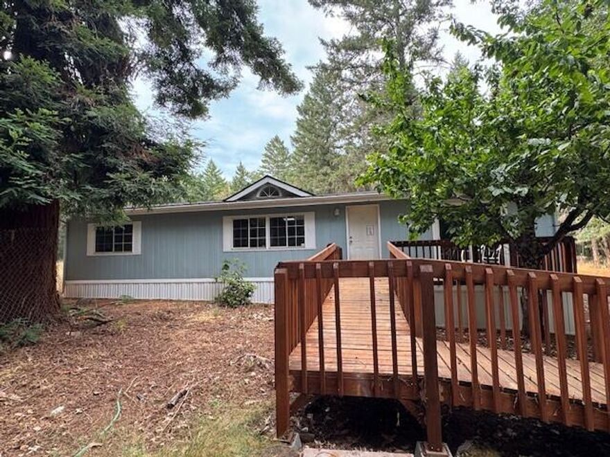 Renovations Complete on this lovely home tucked in the woods on 2.5 private acres! Brand new roof & skirting, in addition to new paint, counter tops, bathrooms, flooring, light fixtures, ceiling fans & doors! This home sparkles & features accessible ramp entry, is 1248 sq ft, 3 bedrooms, 2 full baths with vaulted ceilings, sky lights & open floor plan. The land has been cleared & is a blank slate for your imagination. There is also a detached 2 car garage!