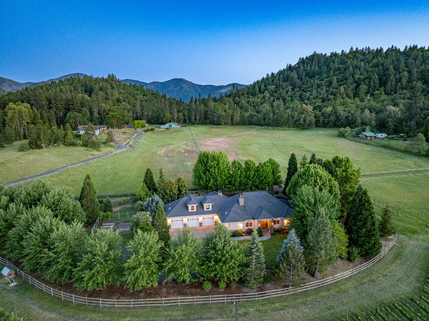 This picturesque Applegate Valley estate offers the perfect blend of luxury, beauty, & versatility. The 3,647 SF custom home features a split floor plan, chef's kitchen, vaulted ceilings, wet bar, rock fireplace, & pellet stove. Outdoor living shines w/lush landscaping, raised garden beds, orchard, two scenic ponds, & gated entry. A first-class building - currently used as a tasting room - adds flexible space for entertaining, hobbies, or future business use across 1,728 SF of thoughtful design. With rich soils, high-producing well, district water rights, & established irrigation infrastructure, the property is ideal for homesteading, livestock, & other agricultural endeavors. The 8.25 net acre vineyard is planted w/Tempranillo, Viognier, & more. The 1,200 SF shop adds even more utility & options for this luxury farm! Currently home to Apricity Vineyard—brand & business not included - but all of the infrastructure & approvals are in place for a buyer to start their own wine business!
