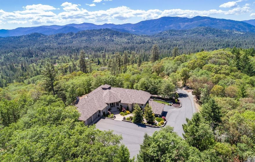 Impeccably crafted with attention to every detail, this custom masterpiece transcends the ordinary. From the grand entry to every specially chosen fixture, this 4900+ s/f, 3 bedroom/3.5 bath beauty will capture your attention & your heart. It is nestled on 11.4 wooded acres in two separate tax lots with two wells and long-range mountain views. Revel in a foodie's paradise-a kitchen outfitted with commercial grade appliances, slab granite, 2 Fisher Paykel dishwasher drawers, double ovens, split kitchen islands with separate prep sink, and a wine captain set in a gorgeous wet bar in the living areas. Superior quality is showcased in Brazilian Lyptus wood cabinets, teak floors and a unique alcohol burning fireplace, plus a master suite complete with a heated jetted tub and stunning tile walk-in shower. State-of-the-art electronics, full outdoor kitchen with fireplace on a spacious covered terrace for entertaining. Also-4 car attached garage plus 2 car carport/RV parking.