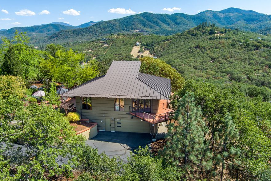 This truly stunning home is situated on a 5.2 acre knoll-top with amazing views of the valley, orchards, city, mountains.  Renowned designer Dale Shostrum built the home with thoughtful input from the owners, completed in 2009. The large Clerestory windows capture the almost 360 degree views and offer lots of light along with the skylights, all with electronic blinds. Geothermal heated tinted concrete floors on both levels keep the home comfortable year round under foot. Custom cherrywood cabinets and staircase, with solid fir doors and wood benches add to the beauty and warmth. Mostly main level living with wrap around deck and patio. This home really does have it all with high end finishes throughout that exude quality yet doesn't feel ostentatious. 1.2 acres of Irrigation from TID allows for landscaping and gardening if desired. A private gate with code affords privacy and security. A home this special doesn't come along very often so don't miss your chance to make it yours!