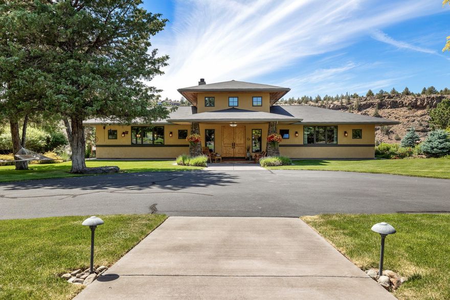 Once in a lifetime opportunity to own a Frank Lloyd Wright inspired canyon estate with stucco siding on 3.53 acres with Cascade Mountain views overlooking the Deschutes River. This magical property includes a 2648 sqft home with an open floor plan, his & hers bathroom suites, loft-style office and/or 3rd bedroom, lava rock fireplace wall separating the open living area from the primary bedroom, solid Alder doors, Brazilian Cherry Wood & Turkish Travertine floors, and 8' window walls for loads of natural light and enjoying the views. This property includes a 256 sqft studio/ 1 bath guest apartment above the detached garage. The detached garage has a bonus office and/or media room with a sink/mini bar. Enjoy the dramatic sunsets from the back deck, listening to soft music from the built-in sound system, in the hot tub, or in the front courtyard under the gazebo by the Saltwater pool! This is a lush fully landscaped and gardener's dream property. Complete with a large RV storage/shop!