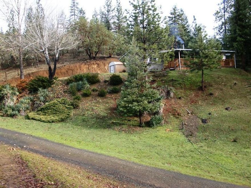 Beautiful views from this wonderful property located less than ten minutes from the Ruch Country Store! Relax on the huge covered porch and take in the pine covered hills surrounding this home. Over 2 acres that back up to BLM Land, enjoy the privacy and the easy access to the Government Owned Land. This three bed, two bath home has an open floor plan. The kitchen is light and bright with a big island for prep and seating, as well as plenty of storage and counter space. There is a nice dining area located between the separate living and family rooms. The wood stove heats the entire home with a cozy warmth, to supplement the electric heat. Recent upgrades include the beautiful laminate flooring. The Master Suite has a spacious bathroom and a large walk in closet. The front entry leads out onto the huge covered deck, which offers great views and a place to entertain in the shade. This is a great place for someone who wants a little space and privacy.