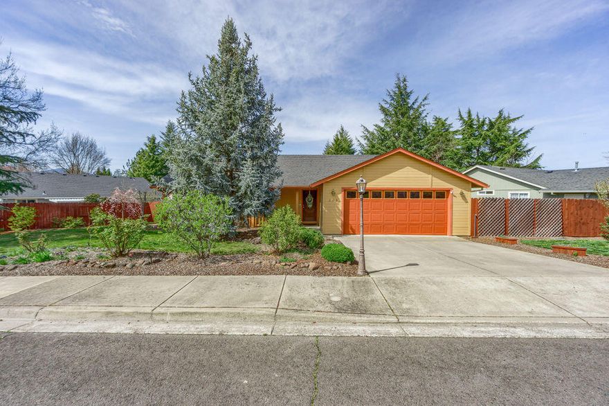 Beautifully maintained single level home in a sought-after Phoenix neighborhood. Durable laminate flooring throughout the primary living areas including the kitchen, dining and great rooms. Vaulted ceiling, gas fireplace as well as a freestanding woodstove add warmth and charm to the great room. Slider access to a spacious deck provides great opportunity for outdoor entertaining. Open kitchen with ample storage, breakfast bar and pantry. The owner's suite is spacious, has a walk-in closet, private bathroom, a slider access to the private backyard. Two additional bedrooms, a shared bathroom, interior laundry and two car attached garage. Situated on a spacious lot with mature trees, there is plenty of space for pets, gardens, outdoor entertaining and more. Side yard has an RV gate with plenty of room for parking, though access would need to be improved.