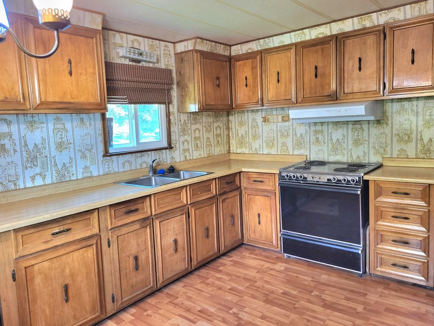 Retro-fitted by Access means upgraded roof insulation with roof cap, dbl-payne windows and large heatpump.  Kitchen with bar, washer, dryer, fridge, range and riding mower included!  Beautiful lot with shed and big multiple car parking area with more enclosed storage.  Additional extra bonus room for even more storage or shop.  Garden areas front and back and vast mountain and meadow views surround this quiet senior park located outside of Jacksonville.