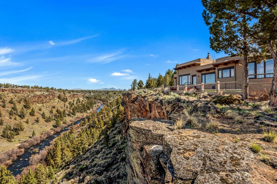 Enjoy breathtaking sunsets and stunning views of a gorgeous river canyon, the Cascade

Mountains and Smith Rock from this Santa Fe style home on a bluff overlooking the Deschutes River. The 2.69 acres extend to the river, across from public land.  Adobe style elements throughout with exposed beams and wood inlay ceilings, a central fireplace, tile floors with radiant heat. Private primary suite with views and separate patio.  Multiple outdoor spaces for enjoying the high desert landscaping and sounds of the river. In addition to a 2-car attached garage, there is a detached shop for hobbies or staging outdoor adventures. This private single-level home has a gated entry, looks out to County and BLM land across the River, with a location convenient to outdoor recreation and the Redmond airport.