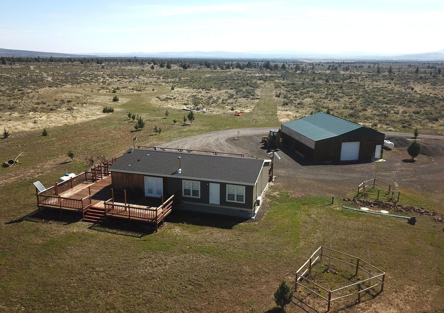 Amazing opportunity to own 190+ acres in Central Oregon minutes away from Lake Billy Chinook! This spacious level off-the-grid acreage is located with 360 degree unobstructed views of the Cascade Mtns. & surrounding territory, peaceful & secluded yet close to all recreation in C.O. Property has permitted custom 2018 manufactured home w/1344 sf, move-in-ready w/great open floor plan. Chef's kitchen w/generous counter space & storage & all appliances include.  Great room w/ Quadrafire wood burning fireplace & amazing views. Primary bedroom w/roomy bath & walk-in closet & Cascade views.  The guest bedroom is also good sized w/over-sized closet. The guest/hall bath is also quite generous. In addition, there is a large laundry rm w/ample storage, washer-dryer included, & mandoor to huge wrap-around deck w/wood accents. 48 X 36 shop w/drive-thru roll-up doors, houses the 2-2500 gal cisterns-water from the newly installed private well AND so much more. See Amenities Sheet. Book appt. to view