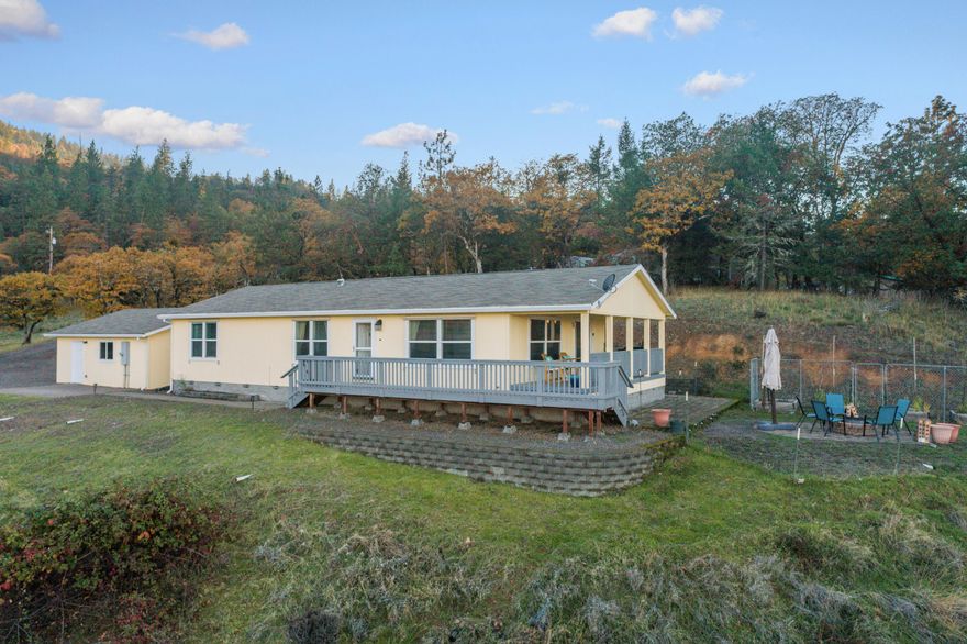 If you are looking for beautiful sunrises, a quiet home w/ lots of trees, wildlife & plenty of space for your needs, then this is one you must see! Enjoy STUNNING PANORAMIC mountain & valley views from this beautiful property located on the hillside of Eagle Point. This manufactured home sits on just over five acres. There are 2 bedrooms and an open office that could be 3rd bedroom. Open floor plan &  lg kitchen. The living room is spacious w/ lg windows, letting in an abundance of natural light & breathtaking views! The primary suite has a walk-in closet & lg bathroom w/ dual sinks. Home also boasts convenient remote-controlled lighting! Outdoor features inc, lg covered deck, patio,& garden beds. With a detached 2-car garage, shed, & RV parking there is plenty of space for your vehicles, toys & hobbies.  Now is the time to see the gorgeous autumn colors from this spectacular location on the hillside! Do not miss this opportunity, it could be all yours!!